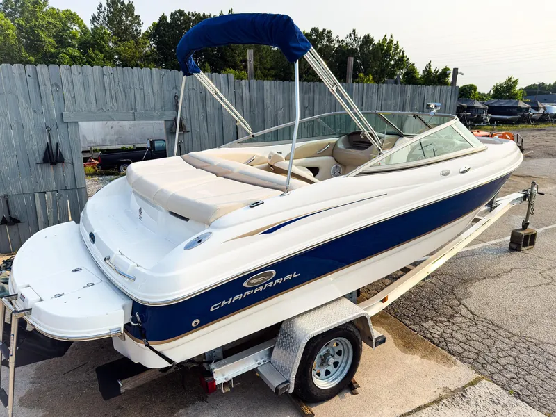 Slide: The Image of 2007 Chaparral 190 SSi boat on trailer, blue and white, with canopy, parked outdoors. - 31