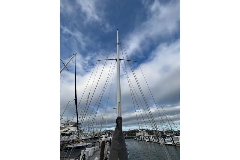 Slide: The Image of Tall mast of a 1970 King's Cruiser 29 sailboat against a cloudy sky in a marina. - 10