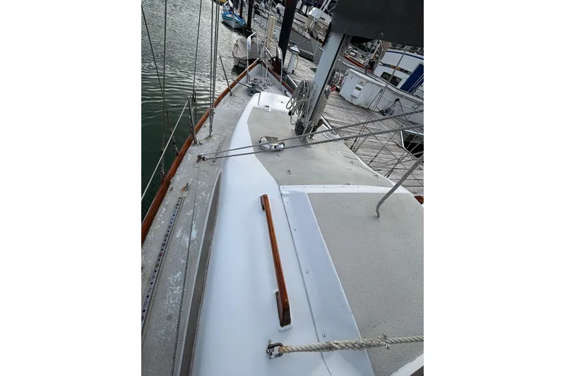 Slide: The Image of 1970 King's Cruiser 29 sailboat deck view at marina, showcasing rigging and wooden accents. - 11