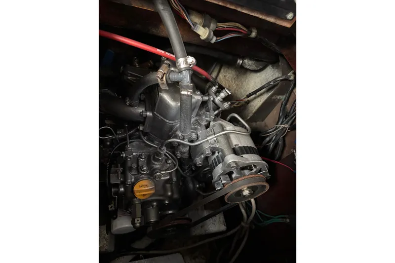 Slide: The Image of Engine compartment of a 1970 King's Cruiser 28 sailboat, showcasing mechanical components and wiring. - 13