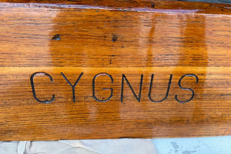 Slide: The Image of Polished wooden surface with "CYGNUS" engraved, from a 1970 King's Cruiser 28 sailboat. - 15