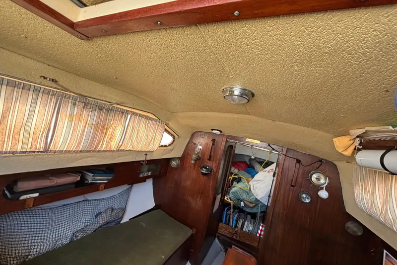 Slide: The Image of Interior of a 1970 King's Cruiser 28 sailboat with wooden paneling and storage. - 19