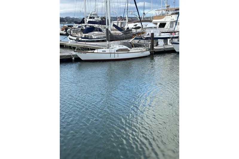 Slide: The Image of 1970 King's Cruiser 29 sailboat docked in a marina, surrounded by other boats. - 2