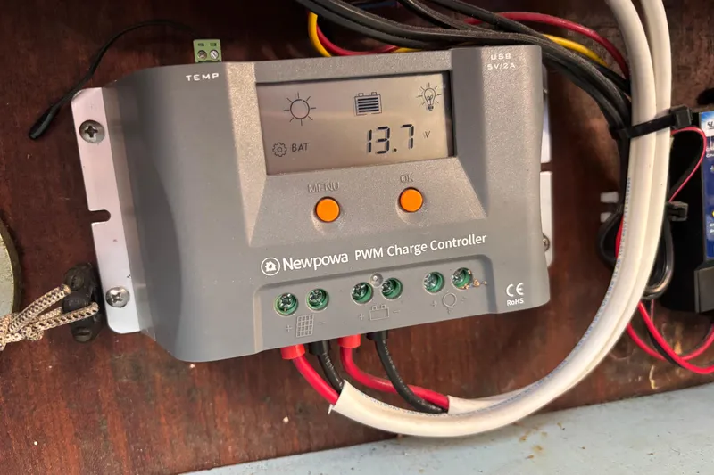 Slide: The Image of Newpowa PWM charge controller displaying 13.7 volts on a King's Cruiser 28, 1970 model. - 21