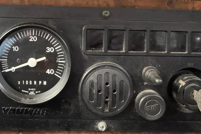 Slide: The Image of Dashboard of a 1970 King's Cruiser 28 with RPM gauge and ignition key. - 22