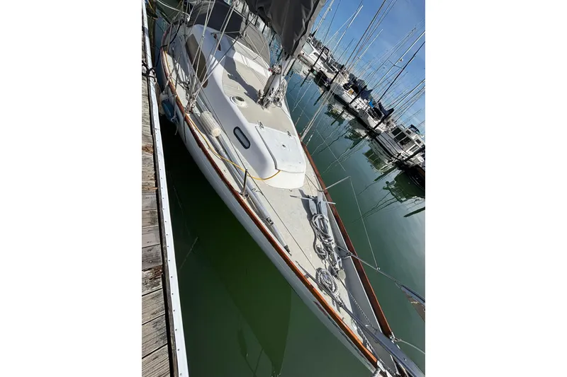 Slide: The Image of Sailboat King's Cruiser 28, 1970 model, docked in a marina with clear water. - 4