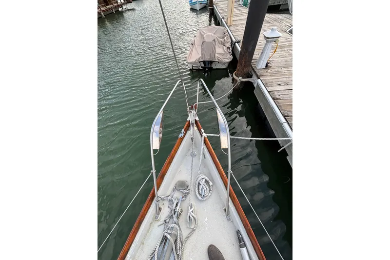 Slide: The Image of Bow view of a 1970 King's Cruiser 29 sailboat docked at a marina. - 5
