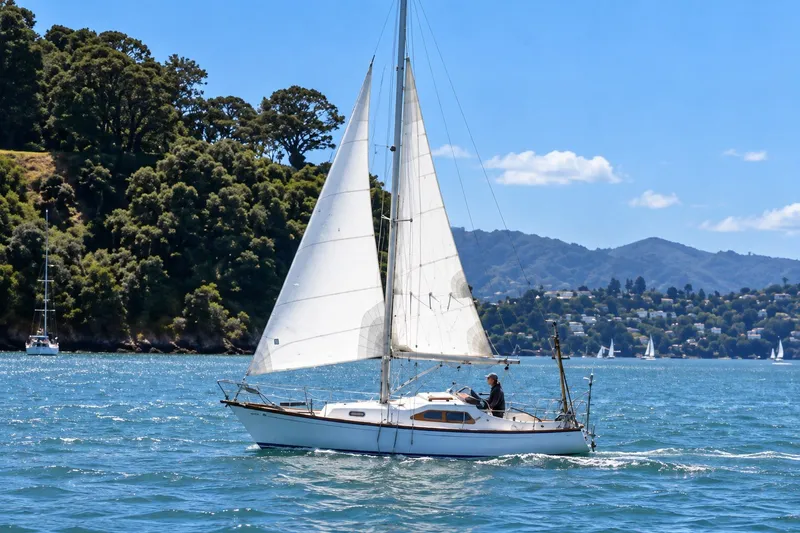 The Image of Vintage 1970 Fiskars Kings Cruiser 29 sailboat navigating scenic coastal waters. - 0