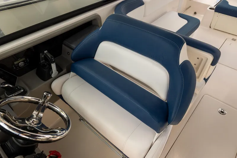 Slide: The Image of 2019 Robalo R317 Dual Console boat interior with blue and white seating and steering wheel. - 10
