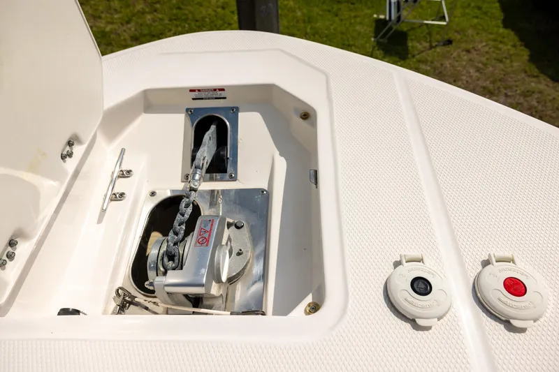 Slide: The Image of Anchor compartment of 2019 Robalo R317 Dual Console boat, featuring chain and winch. - 16