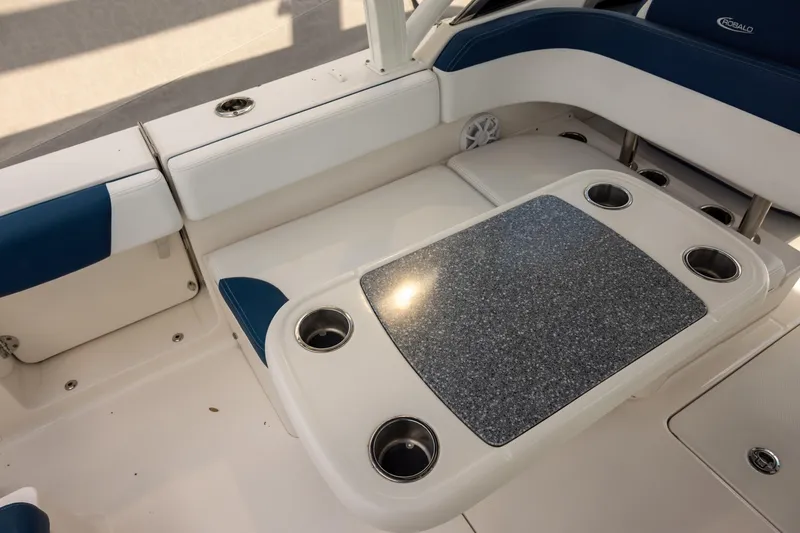 Slide: The Image of 2019 Robalo R317 Dual Console boat interior with cushioned seating and table with cup holders. - 6