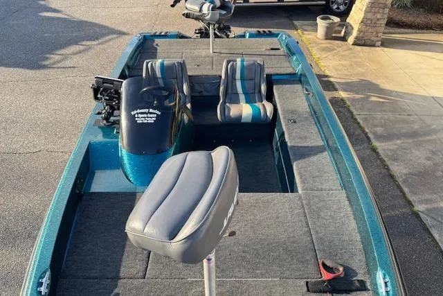 Slide: The Image of 1994 Javelin 389T fishing boat with seating and motor, parked on pavement. - 6