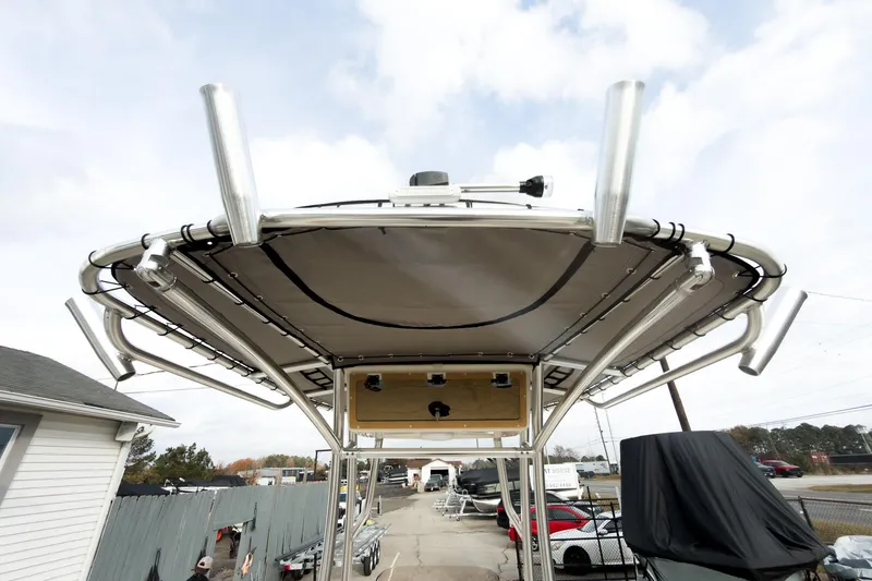 Slide: The Image of 2025 Carolina Skiff 21 Ultra Elite boat with T-top and rod holders, parked outdoors. - 22