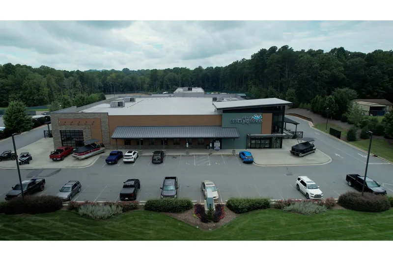 Slide: The Image of Aerial view of Rock Outdoors store with parked vehicles, including a Barletta Cabrio 22QC boat. - 4