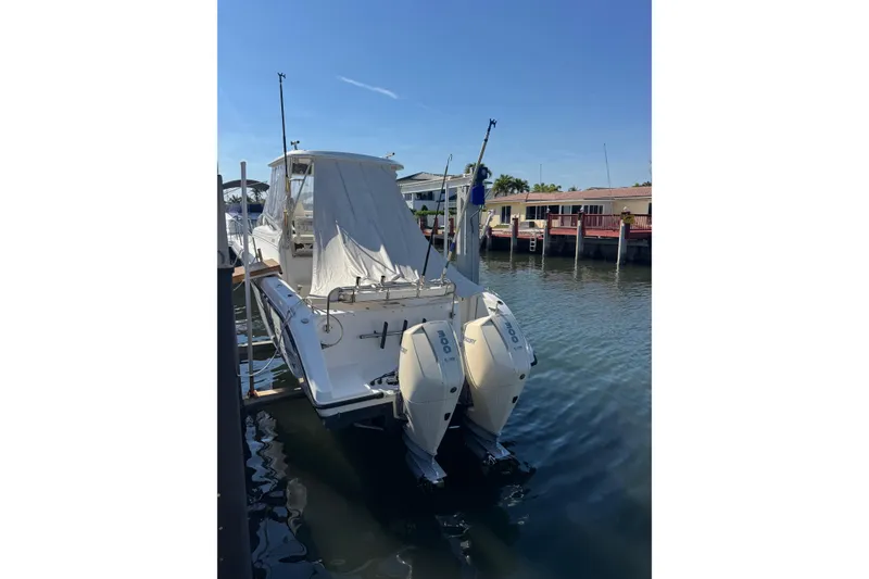 The Image of 2005 Century 3200 Walk-Around boat docked with twin outboard engines. - 1