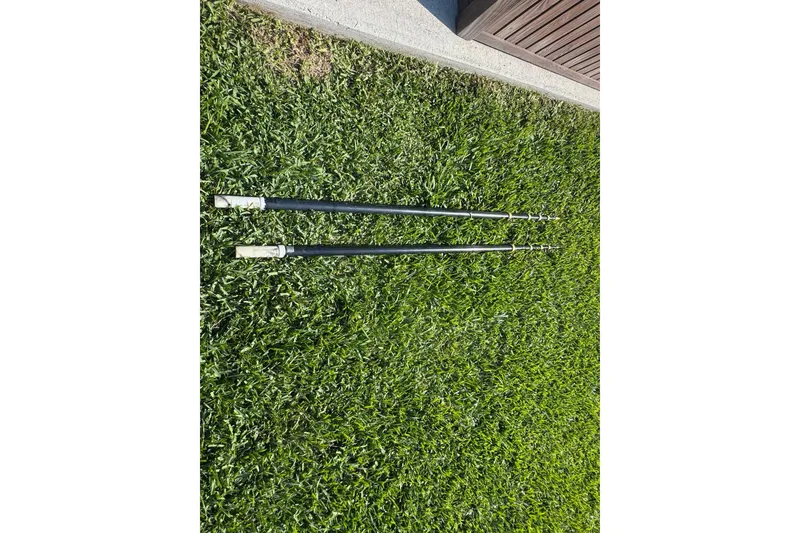 Slide: The Image of Two black poles on green grass, near a wooden structure. - 101