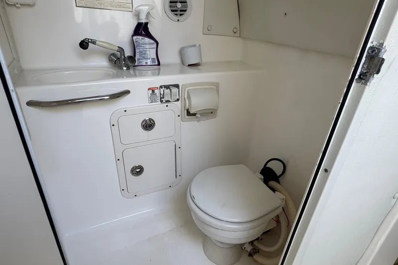 Slide: The Image of Compact marine bathroom in 2005 Century 3200 Walk-Around boat, featuring toilet and sink. - 22