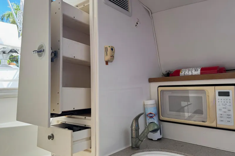 Slide: The Image of Interior of 2005 Century 3200 Walk-Around boat with microwave, sink, and storage. - 27