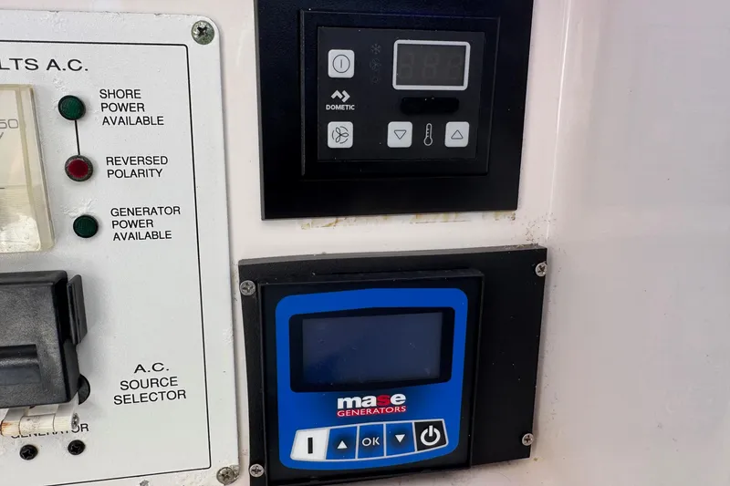 Slide: The Image of Control panels on a 2005 Century 3200 Walk-Around boat, featuring power indicators and generator controls. - 32
