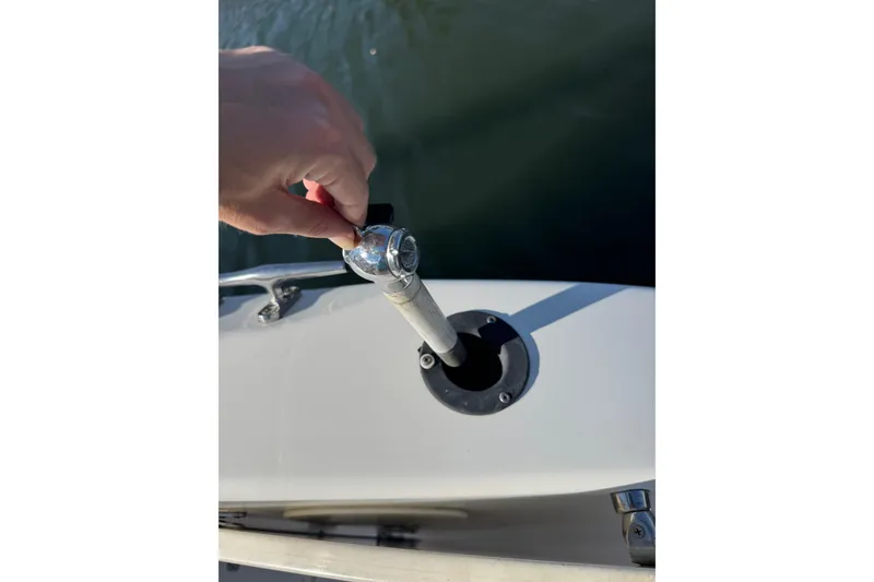 Slide: The Image of Hand adjusting a rod holder on a 2005 Century 3200 Walk-Around boat. - 48