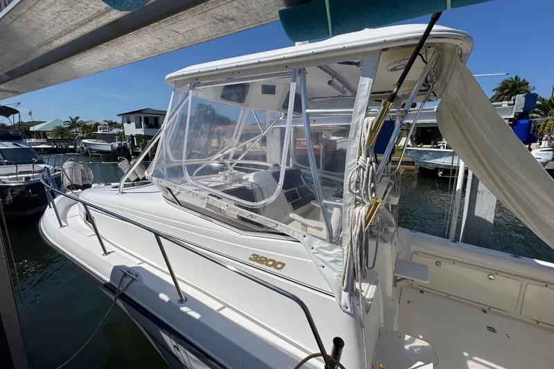 Slide: The Image of 2005 Century 3200 Walk-Around boat docked, featuring clear enclosure and sleek design. - 5