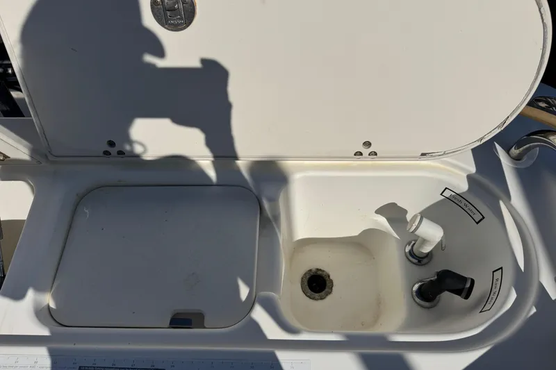 Slide: The Image of 2005 Century 3200 Walk-Around boat sink with open lid and faucet. - 54