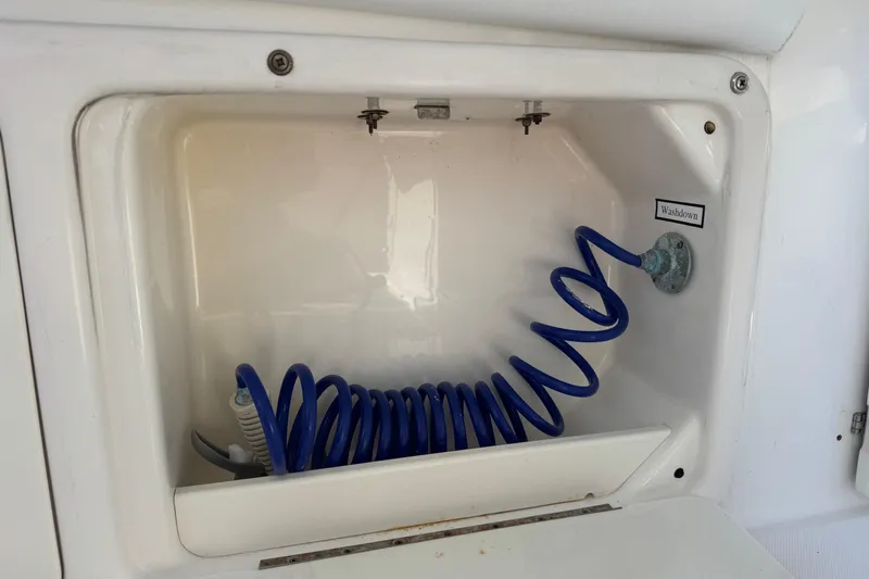 Slide: The Image of 2005 Century 3200 Walk-Around washdown compartment with coiled blue hose. - 63