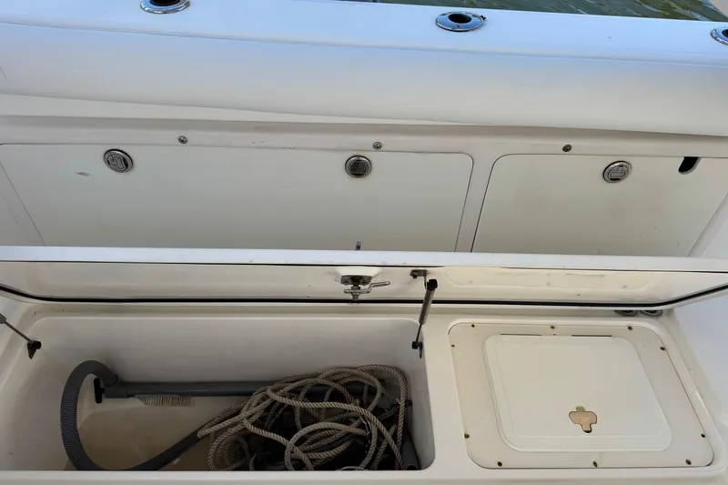 Slide: The Image of Open storage compartment on a 2005 Century 3200 Walk-Around boat, showing ropes and equipment. - 65