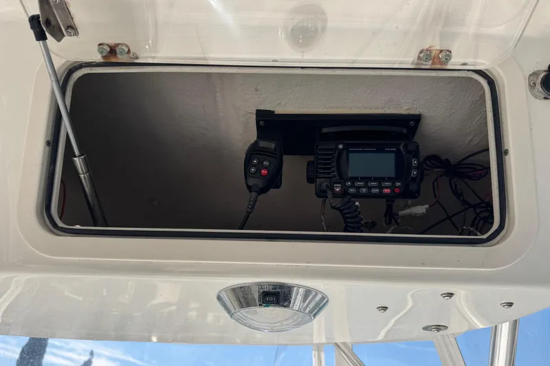 Slide: The Image of Open electronics compartment on 2005 Century 3200 Walk-Around boat, featuring radio equipment. - 69