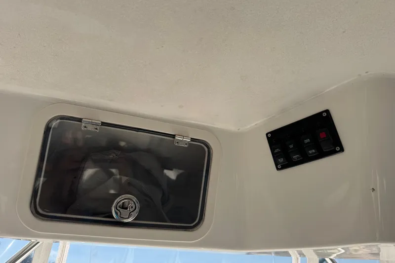 Slide: The Image of 2005 Century 3200 Walk-Around boat interior with storage compartment and control panel. - 70