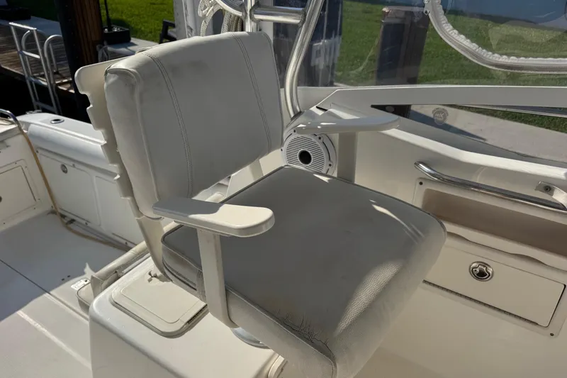 Slide: The Image of Captain's chair on a 2005 Century 3200 Walk-Around boat, featuring white upholstery and armrests. - 73