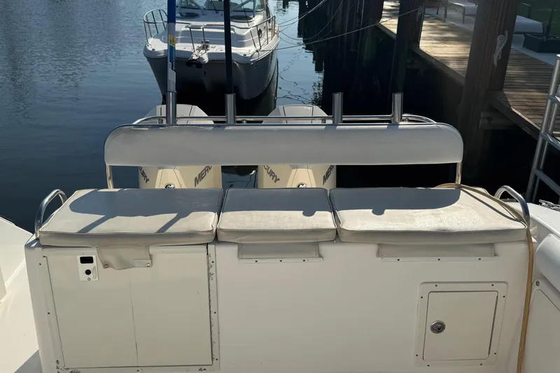 Slide: The Image of 2005 Century 3200 Walk-Around boat with cushioned seating and docked in a marina. - 74