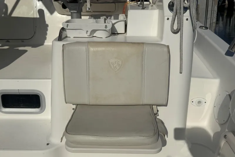 Slide: The Image of Century 3200 Walk-Around 2005 boat seat with emblem, white upholstery, and fishing rod holder. - 75