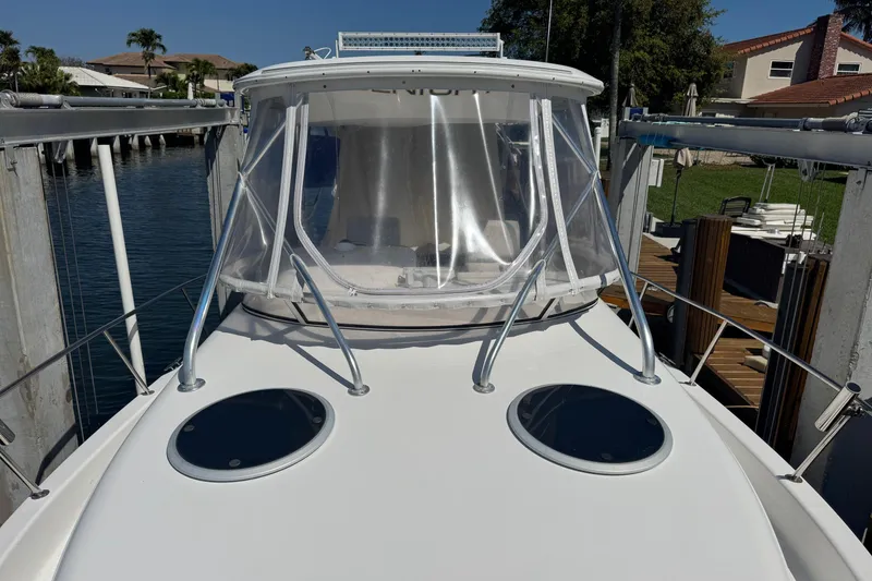 Slide: The Image of 2005 Century 3200 Walk-Around boat docked, featuring clear canopy and dual hatches. - 9