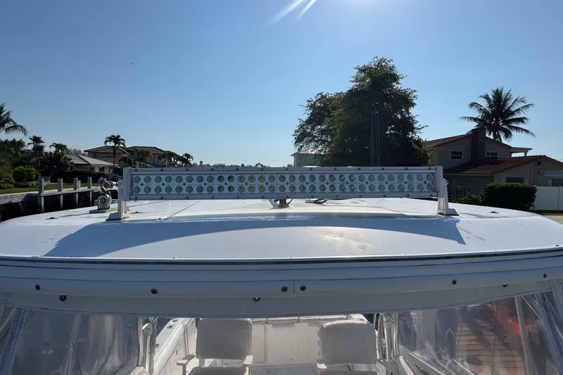 Slide: The Image of 2005 Century 3200 Walk-Around boat with rooftop light bar, sunny day, palm trees in background. - 93