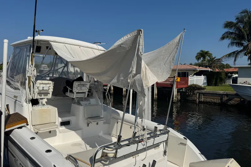 Slide: The Image of 2005 Century 3200 Walk-Around boat docked, featuring a canopy and fishing chairs. - 95