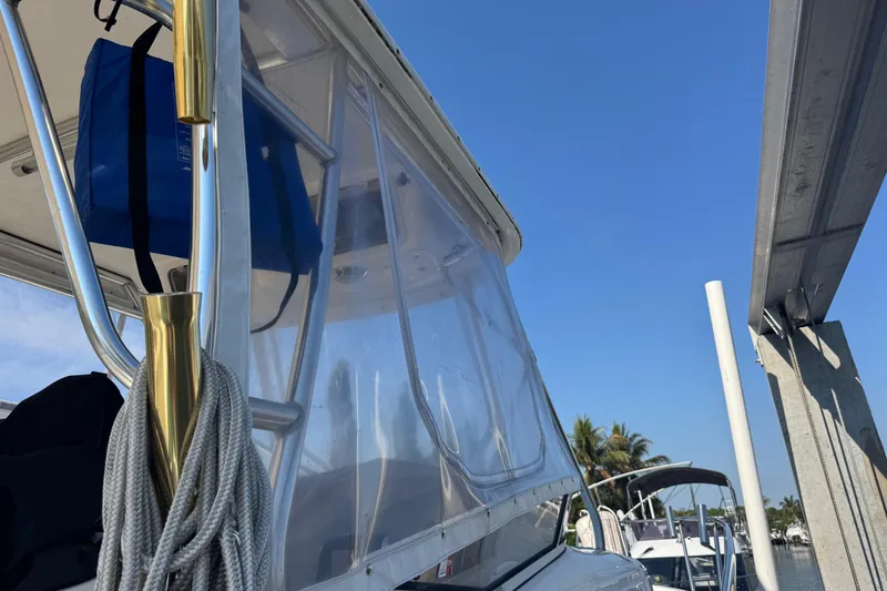 Slide: The Image of 2005 Century 3200 Walk-Around boat with clear enclosure and blue sky background. - 98