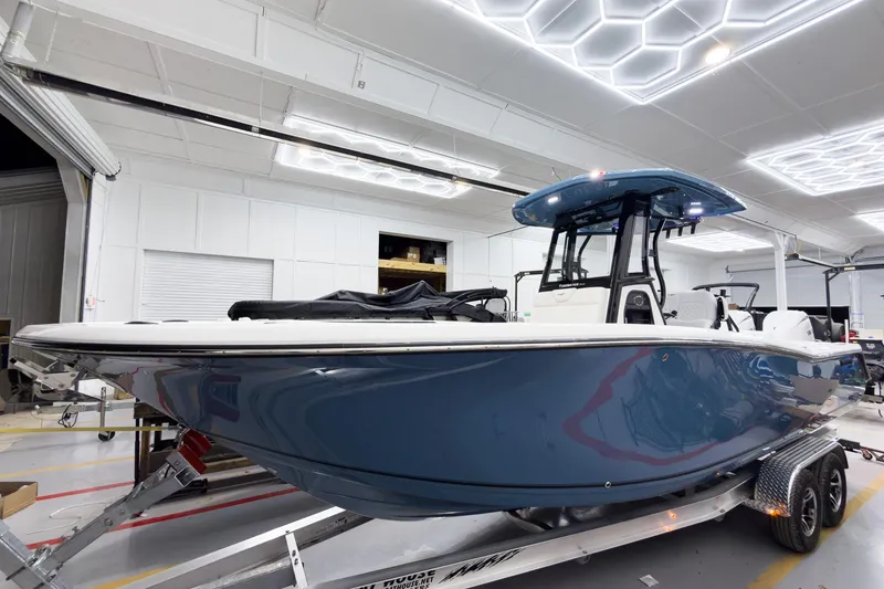 Slide: The Image of 2026 Tidewater 272 CC Adventure boat in showroom, featuring sleek blue design and modern amenities. - 1