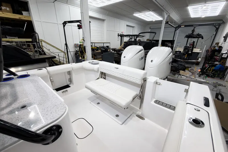 Slide: The Image of 2026 Tidewater 272 CC Adventure boat interior with dual Yamaha engines in a workshop setting. - 12