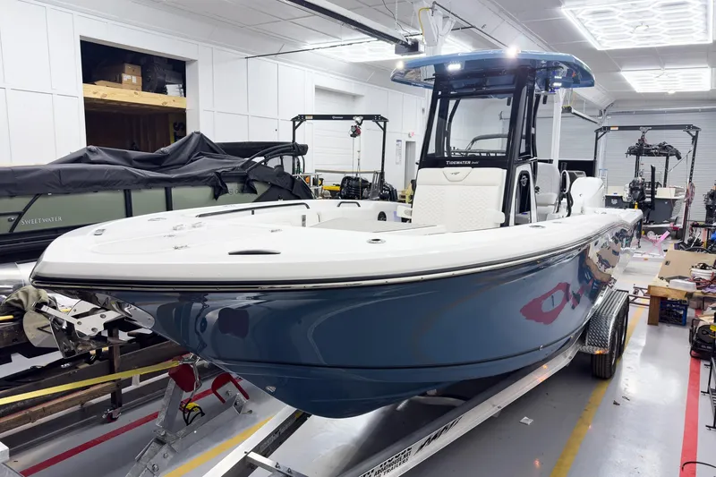 Slide: The Image of 2026 Tidewater 272 CC Adventure boat in a showroom, showcasing sleek design and modern features. - 2