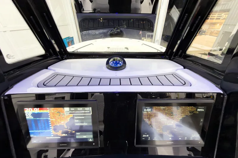 Slide: The Image of 2026 Tidewater 272 CC Adventure boat dashboard with navigation screens and compass. - 20