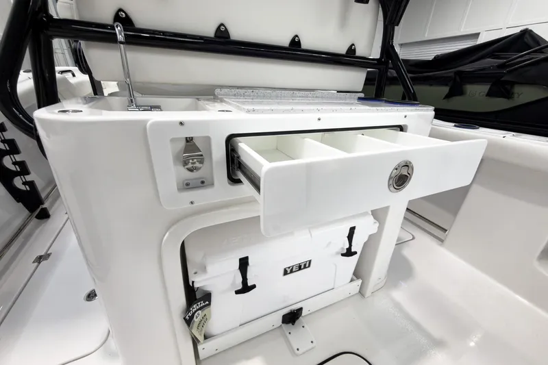 Slide: The Image of 2026 Tidewater 272 CC Adventure boat interior with storage drawers and Yeti cooler. - 30