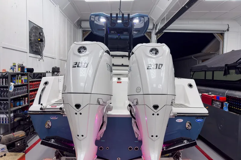 Slide: The Image of 2026 Tidewater 272 CC Adventure boat with dual Yamaha outboard engines in a garage. - 4