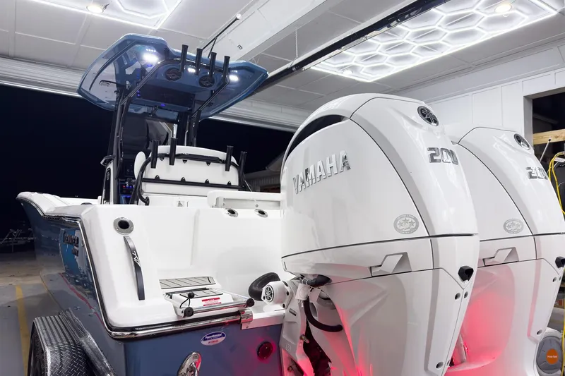Slide: The Image of 2026 Tidewater 272 CC Adventure boat with dual Yamaha 200 engines in a well-lit garage. - 5