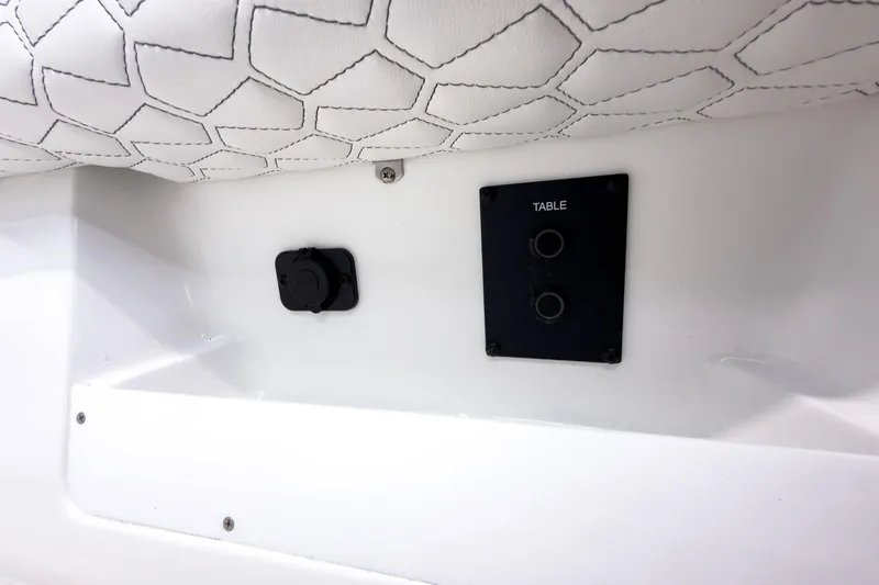 Slide: The Image of 2026 Tidewater 272 CC Adventure boat interior with table mount and white upholstery. - 55