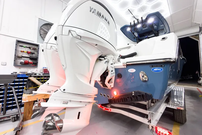 Slide: The Image of 2026 Tidewater 272 CC Adventure boat with dual Yamaha outboard engines in a workshop. - 6