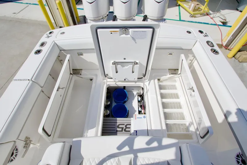 Slide: The Image of 2027 Regulator 35 boat deck with open storage compartments and visible engines. - 33