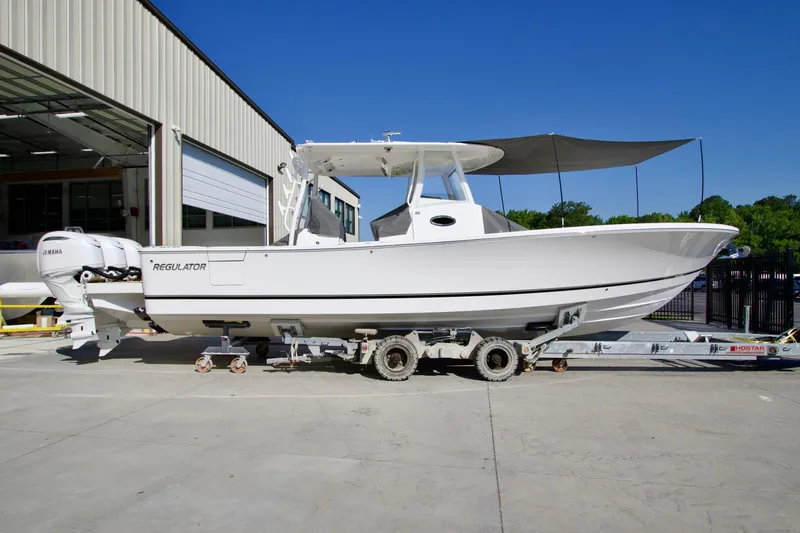 The Image of 2027 Regulator 35 boat on trailer, parked outside a building under clear blue sky. - 2