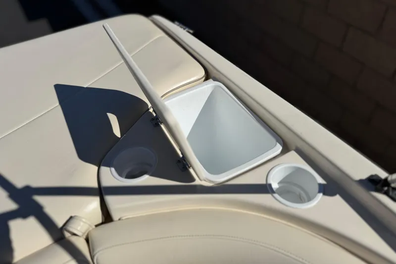 Slide: The Image of 2003 Rinker 192 Captiva Bowrider interior with open storage compartment and cup holders. - 18