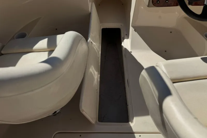 Slide: The Image of Interior view of a 2003 Rinker 192 Captiva Bowrider boat, featuring seating and storage. - 21
